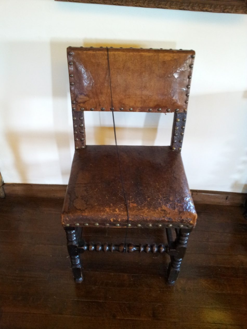 A chair upholstered in leather.Chairs were upholstered from at least the 16th Century.
