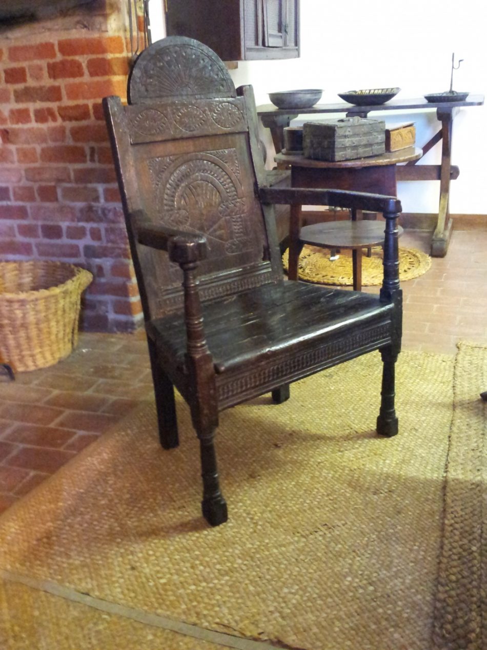 An carved oak chair with arms.
