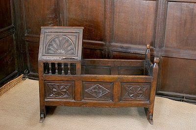 An elaborate carved rocking cradle.
