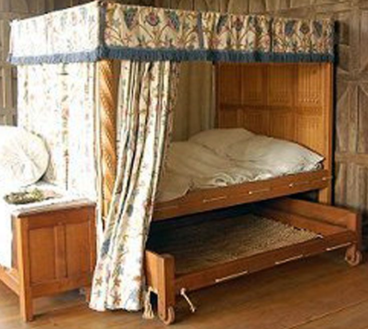 A posted corded bed with a truckle in a wealthy household.It has 5 curtains and a valence. Bed cords trussed between holes in the bed frame to support the mattresses.The cords could be tightened to give better support which led to the saying 