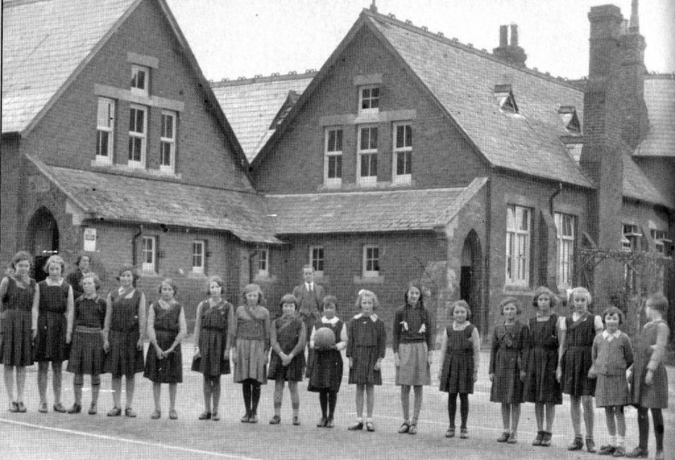 The Pirton netball team with headmaster Mr Bryant in the background