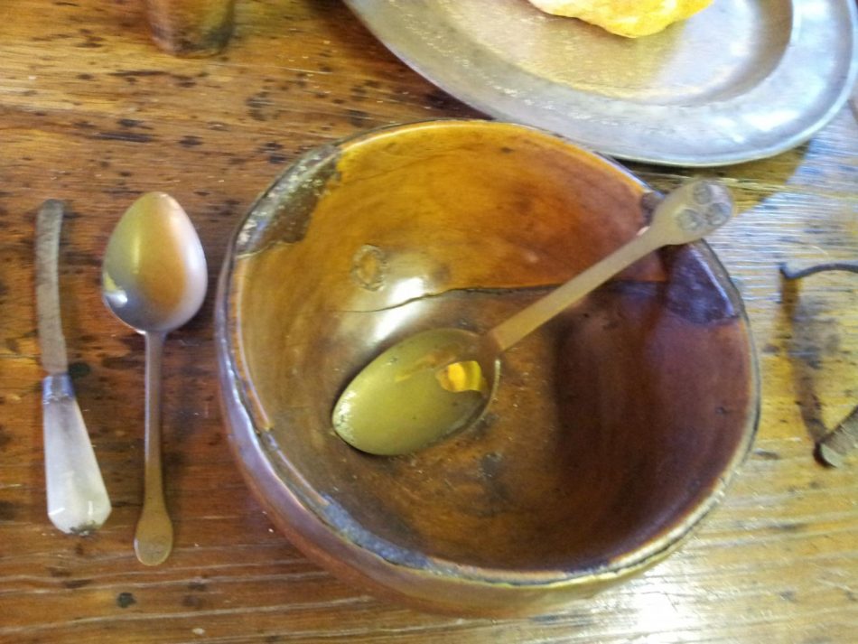 A wooden turned bowl with a pewter spoons. Note the spoon and knife for eating, forks were uncommon in 17th century inventories.
