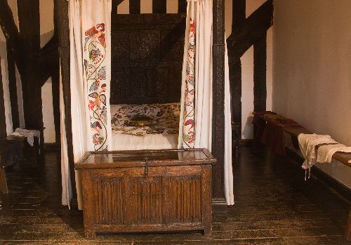 A grander bed with  hand embroidered crewel work curtains.the beds often had 2  mattresses ,made of feather, flock or in poorer cases straw.